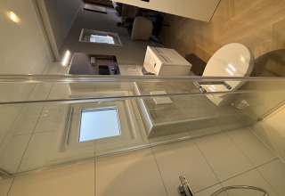 Piccolo bagno moderno e area soggiorno in un Tiny Loft al Veluwepark de Bosgraaf, Paesi Bassi.