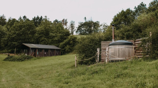 Tienda safari con ducha caliente privada y jacuzzi en un entorno natural en Feather Down Rochefort-Ardenne, Bélgica.