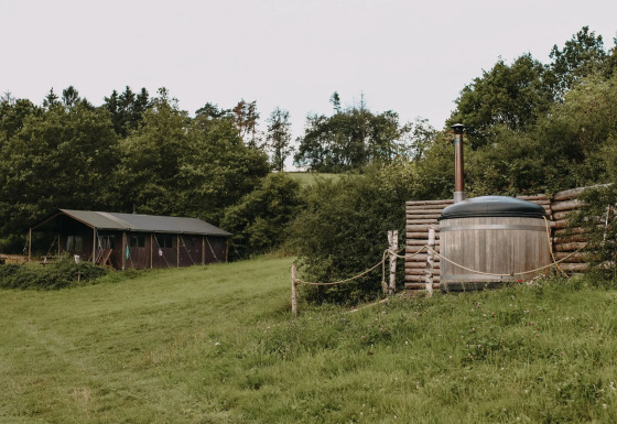 Tienda safari con ducha caliente privada y jacuzzi en un entorno natural en Feather Down Rochefort-Ardenne, Bélgica.