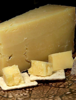 Queso Cheddar maduro en bloque y en cubos sobre galletas, fotografiado cerca de Cheddar Gorge, Inglaterra.