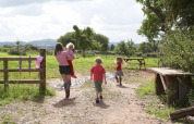 En familie går på en sti i det grønne landskab ved Feather Down Hollings Hill i West Midlands, England.