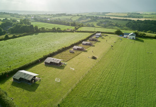 Vista aerea del parco vacanze Feather Down Gwel Teg Farm nel sud-ovest dell’Inghilterra con tende nei campi.