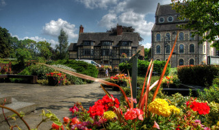 Farverig have med blomster og gamle bygninger i baggrunden, set i Shrewsbury, Wales, Storbritannien.