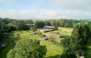 Vue aérienne du parc de vacances Feather Down Manor Farm entouré de champs et d'arbres dans le sud-est de l'Angleterre.