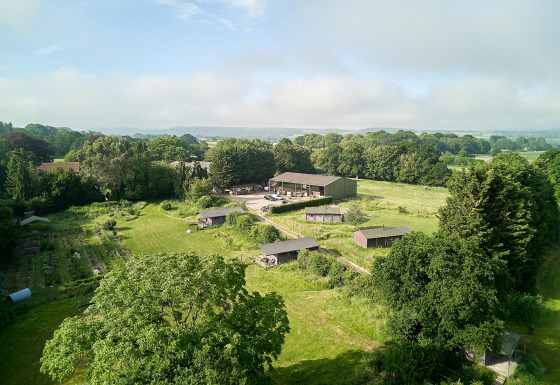 Luftaufnahme von Feather Down Manor Farm, einem Ferienpark mit Feldern und Bäumen in Südostengland.