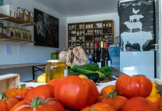 Et udvalg af friske grøntsager, vin og lokale produkter i en butik på Feather Down La Ferme de Fontenille.