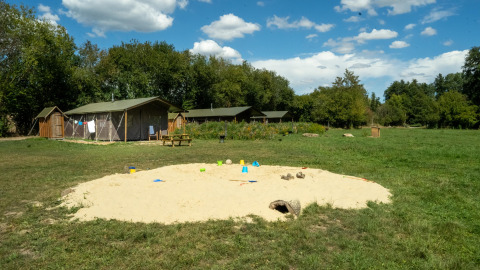 Speelplein met zandbak en tenthutten bij Feather Down La Ferme de Fontenille, vakantiepark in Spanje.