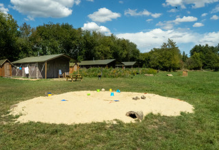 Speelplein met zandbak en tenthutten bij Feather Down La Ferme de Fontenille, vakantiepark in Spanje.