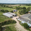 Aerial view of Feather Down New Barn Farm in East England showing barns, fields, and holiday accommodation.