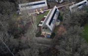 Luchtfoto van Lodge met Jacuzzi: moderne houten lodges met terrassen gelegen te midden van bomen en natuur.