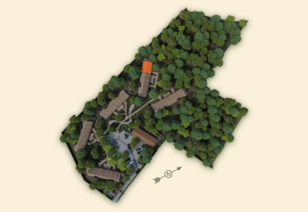 Vista aerea di Lodge with Jacuzzi, edifici immersi tra gli alberi con un tetto evidenziato in arancione.