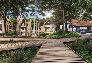 Área moderna de cabañas de madera con pasarelas, vegetación y familias disfrutando del entorno.
