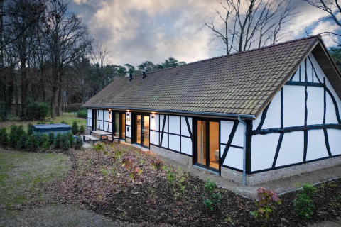 Villa Lodge con jacuzzi en Woodz Lodges, Bélgica, exterior con terraza y fondo de bosque y jardín.