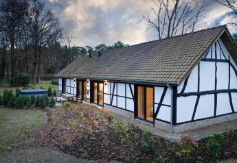Villa Lodge avec jacuzzi aux Woodz Lodges en Belgique, vue extérieure sur jardin, terrasse et forêt.