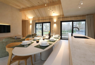 Essbereich und Küche in der Villa Lodge mit Jacuzzi bei Woodz Lodges in Belgien, helles Holzdesign.