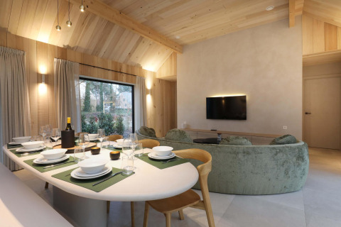 Comedor y sala de estar de Villa Lodge con jacuzzi en Woodz Lodges, Bélgica, con decoración moderna en madera.