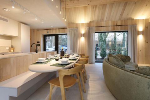 Salle à manger et cuisine moderne de la Villa Lodge avec jacuzzi chez Woodz Lodges, Belgique, grandes fenêtres.