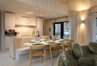 Modernes Küchen- und Esszimmer in der Villa Lodge mit Jacuzzi bei Woodz Lodges in Belgien, warmes Flair.