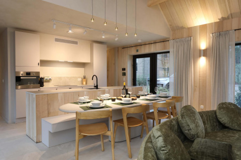 Cocina moderna y comedor en Villa Lodge con jacuzzi en Woodz Lodges, Bélgica, ambiente acogedor y elegante.