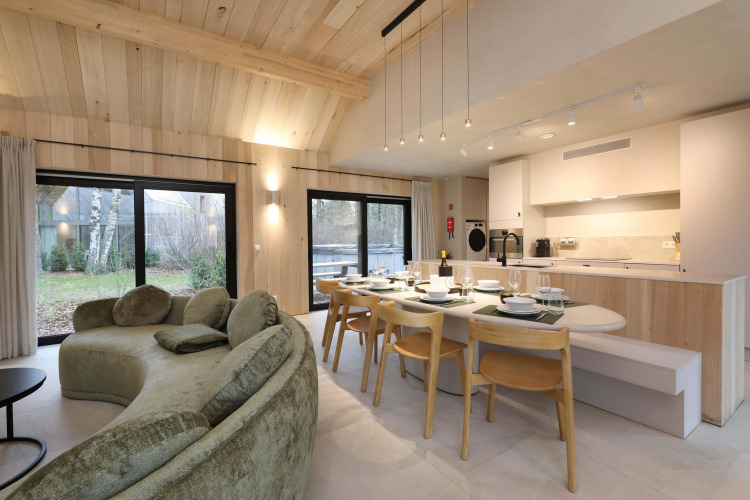 Modernes Wohnzimmer und Küche in der Villa Lodge mit Jacuzzi in den Woodz Lodges, Belgien, mit viel Licht.