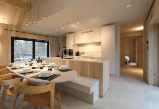 Moderne keuken en eetruimte in Villa Lodge met jacuzzi bij Woodz Lodges, België, in lichte houtstijl.