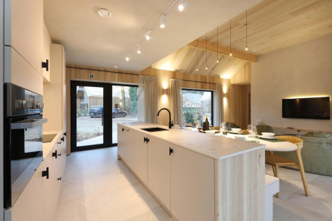 Cocina y sala de estar modernas de planta abierta en Villa Lodge con jacuzzi en Woodz Lodges, Bélgica.