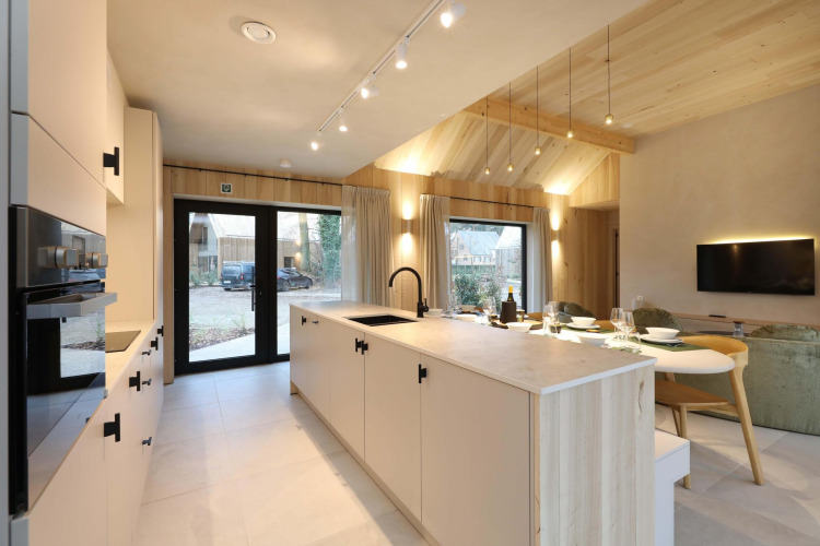 Modernes, offenes Küchen- und Wohnbereich in der Villa Lodge mit Whirlpool bei Woodz Lodges, Belgien.