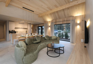 Moderne woonkamer en keuken in Villa Lodge met jacuzzi bij Woodz Lodges in België, uitzicht op tuin.