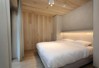 Modernes Schlafzimmer in der Villa Lodge mit Jacuzzi bei Woodz Lodges in Belgien, Holzwände.