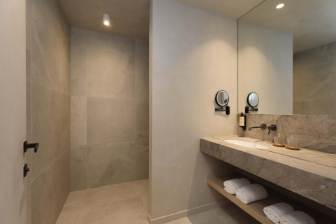 Moderne badkamer van Villa Lodge met jacuzzi bij Woodz Lodges in België, met grote spiegel en douche.