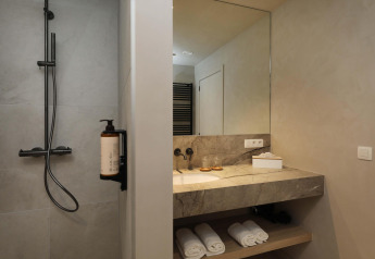 Moderne badeværelse med bruser og spejl på Villa Lodge med jacuzzi i Woodz Lodges, Belgien.