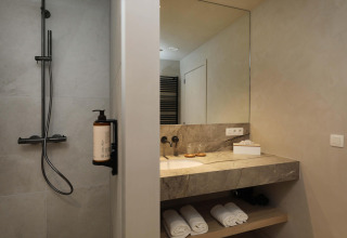 Modernes Bad mit Dusche und Spiegel in der Villa Lodge mit Jacuzzi bei Woodz Lodges, Belgien.