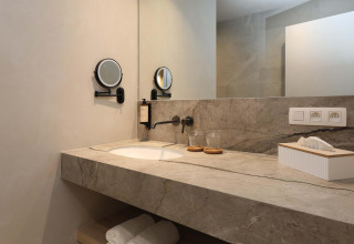 Moderne badkamer met marmeren wasbak en spiegel in Villa Lodge met Jacuzzi bij Woodz Lodges, België.