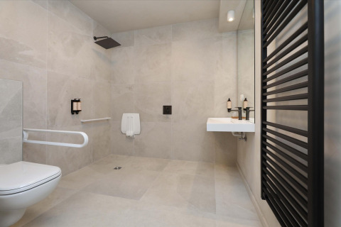 Baño accesible en Villa Lodge con Jacuzzi en Woodz Lodges, Bélgica, con diseño moderno y espacioso.