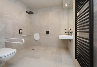 Rolstoeltoegankelijke badkamer in Villa Lodge met jacuzzi bij Woodz Lodges in België, moderne uitstraling.