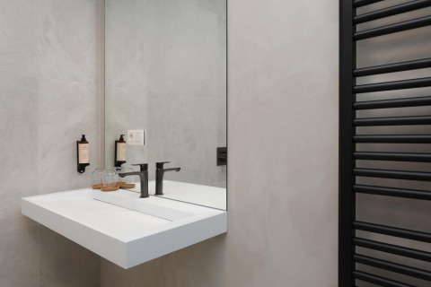 Modernes Badezimmer mit Waschbecken und Spiegel in der Villa Lodge mit Jacuzzi bei Woodz Lodges in Belgien.