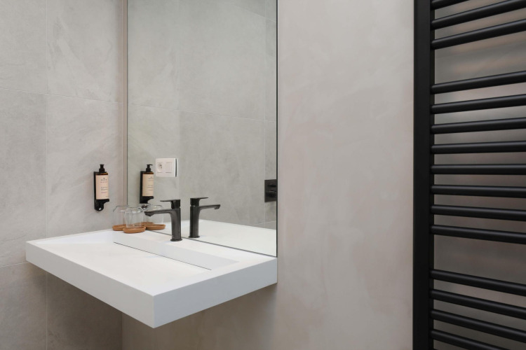 Modernes Badezimmer mit Waschbecken und Spiegel in der Villa Lodge mit Jacuzzi bei Woodz Lodges in Belgien.