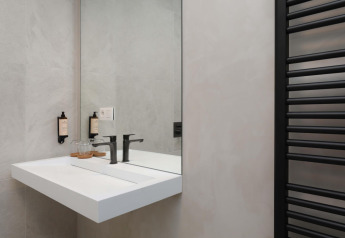 Modernes Badezimmer mit Waschbecken und Spiegel in der Villa Lodge mit Jacuzzi bei Woodz Lodges in Belgien.