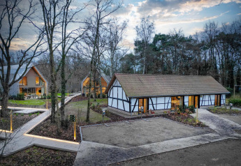 Villa Lodge met jacuzzi bij Woodz Lodges in België, midden in het bos tussen moderne lodges en wandelpaden.