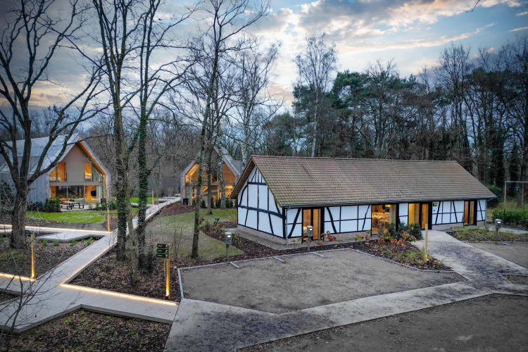 Villa Lodge mit Jacuzzi bei Woodz Lodges in Belgien, umgeben von Wald, moderner Architektur und Naturpfaden.