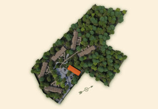 Luftaufnahme der Villa Lodge mit Whirlpool, umgeben von Wald bei Woodz Lodges in Belgien.