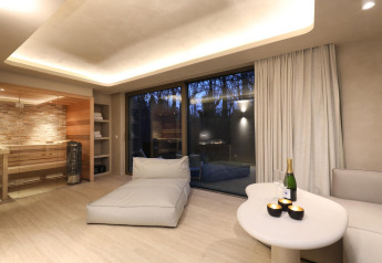 Wellness Suite bei Woodz Lodges in Belgien mit moderner Lounge, Sauna und Blick auf den Abendwald.