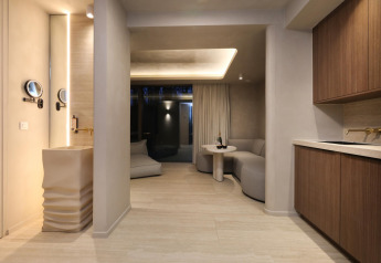 Moderne Wellness Suite bij Woodz Lodges in België met stijlvol interieur, kitchenette en gezellige zithoek.