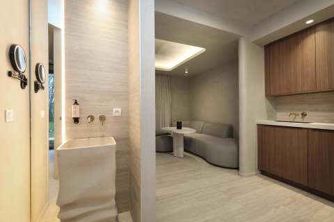 Suite Wellness en Woodz Lodges, Bélgica, con diseño minimalista y cómodos muebles en tonos neutros.
