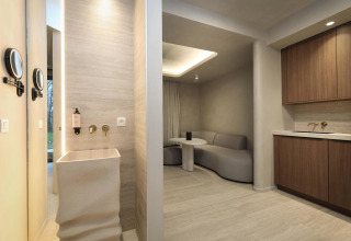 Suite Wellness en Woodz Lodges, Bélgica, con diseño minimalista y cómodos muebles en tonos neutros.