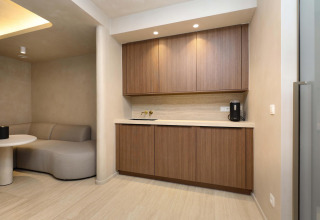 Suite de bienestar moderna en Woodz Lodges, Bélgica, con gabinetes de madera y ambiente minimalista.