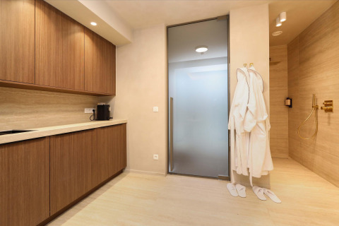 Wellness Suite en Woodz Lodges, Bélgica, con zona de spa moderna, albornoces y armarios de madera.