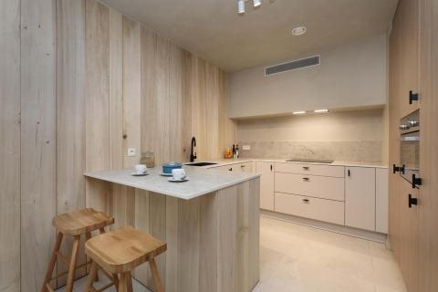 Cucina moderna al Lodge at Woodz Lodges in Belgio, con legno naturale, isola e sgabelli.