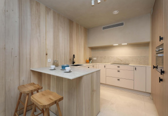 Cocina moderna en Lodge at Woodz Lodges, Bélgica, con madera natural, isla y taburetes.