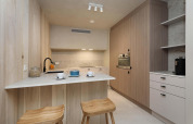 Cucina moderna al Lodge at Woodz Lodges in Belgio con pannelli in legno, sgabelli e design elegante.